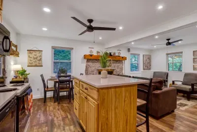 Open-concept great room where the kitchen, dining table, and living area all flow together. Whoever's cooking stays in the conversation — that's the whole point up here.