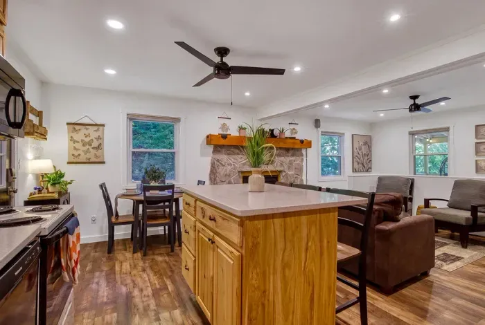 Open-concept great room where the kitchen, dining table, and living area all flow together. Whoever's cooking stays in the conversation — that's the whole point up here.