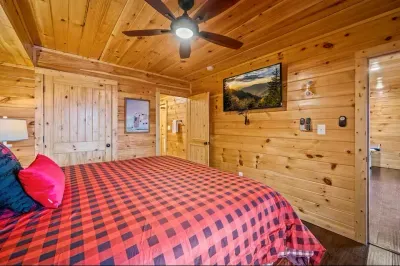 Sleep in style—cozy red bed sheets, TV, and private bathroom