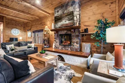 Family room with 2 chairs, a 55-inch smart TV, electric fireplace, pull out sofa, and loveseat.