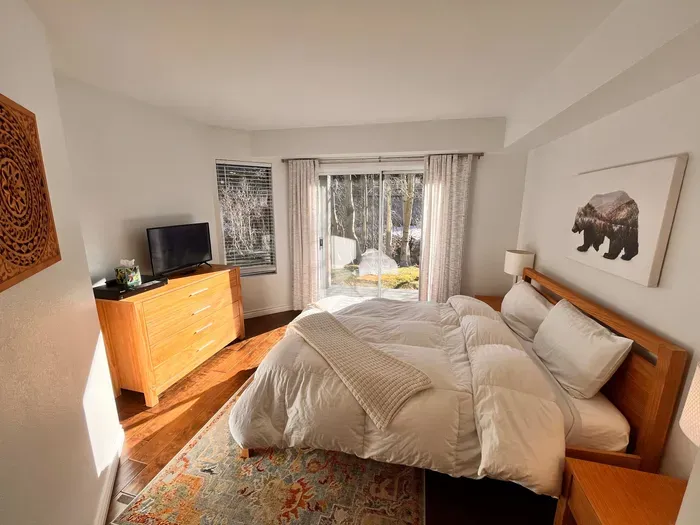 Guest Bedroom 1 with queen bed and slider door to back yard