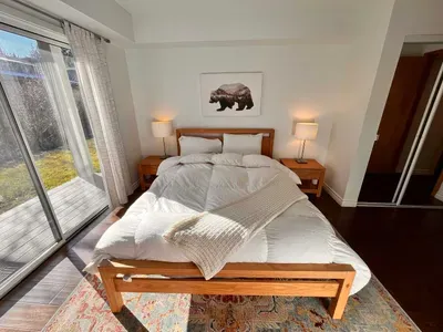 Guest Bedroom 1 with queen bed and slider door to back yard