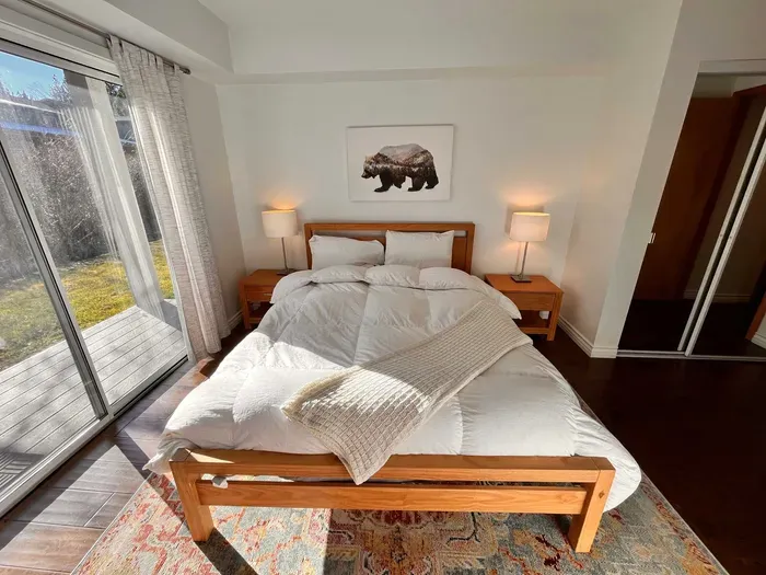 Guest Bedroom 1 with queen bed and slider door to back yard