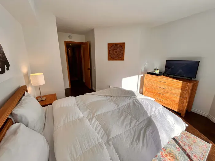 Guest Bedroom 1 with queen bed and slider door to back yard