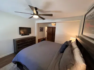 Bedroom with king sized memory foam bed, 40" smart TV, dresser, full closet and attached full bathroom.