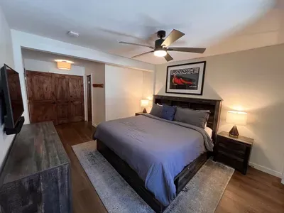 Bedroom with king sized memory foam bed, 40" smart TV, dresser, full closet and attached full bathroom.