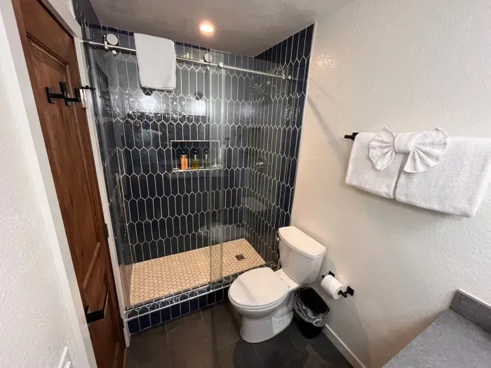 Walk in shower with glass shower enclosure.