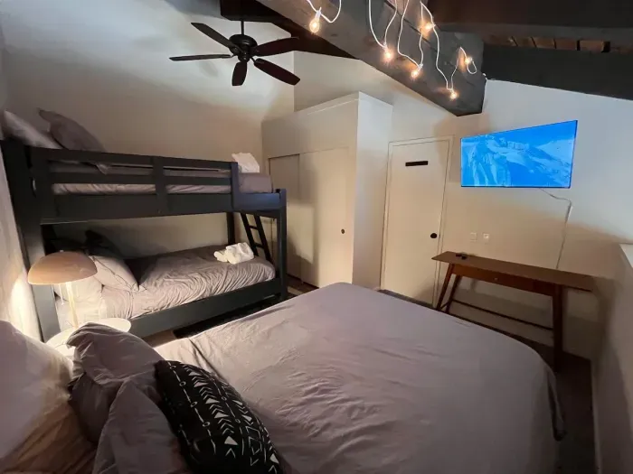Loft sleeping area with a queen and full sized bunkbed. Includes a full sized closet with hangers at the end of the bunkbed and 40" smart TV. Loft has a door to separate it from the upstairs hallway but is open to the downstairs dining area.
