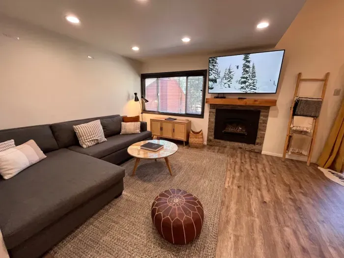 Living room with gas fireplace and 65" smrt TV.