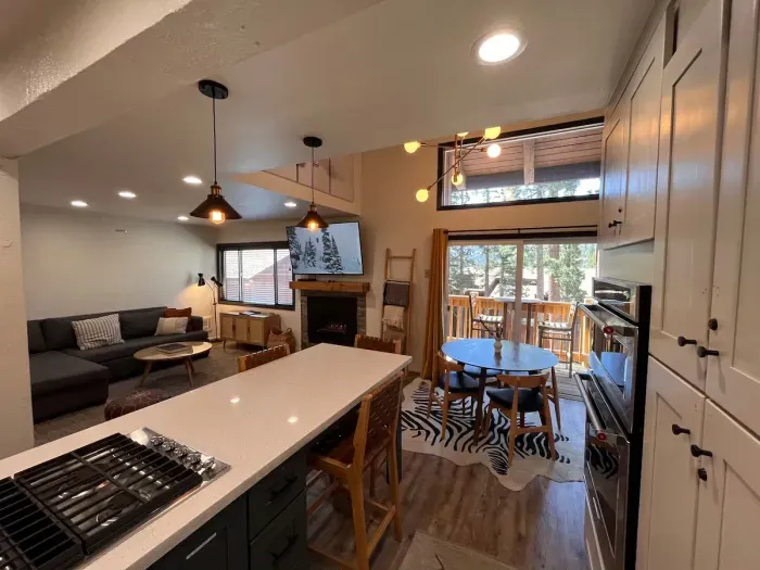 Living room dining area and private deck viewed from kitchen.