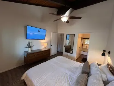 Bedroom with a king bed, cealing fan, 65" smart TV and attacherd bathroom.  Bathroom can be accessed from either the hallway or bedroom with privacy doors securing both entrances.