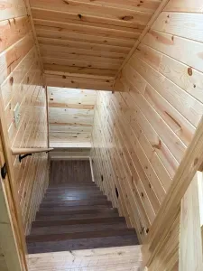 Main level stairway down to the finished lower level entertaining area, 85" smart TV, 2nd kitchen, 4-person dining room& gaming table, 2 QB bedrooms, full bathroom #3, and walk out to fire pit area, private dock, & lake