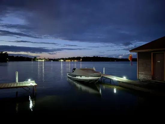 summer sunset view of the lake from 5RK lodge illuminated boat dock and swim area