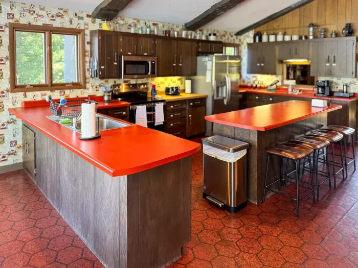 View of the full kitchen and the center island eat-in seating for four and with visibility across the entire great room, dining, living room, entertainment space
