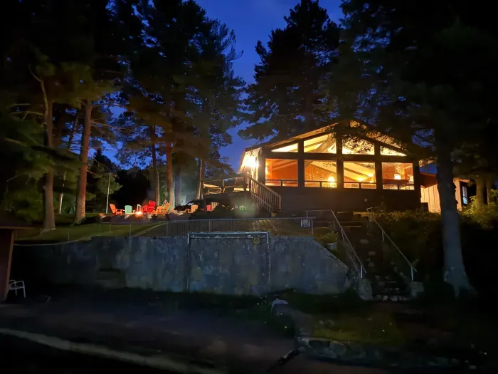 post sunset view from dock of 5RK Lodge great room and adjoining deck and fire pit area