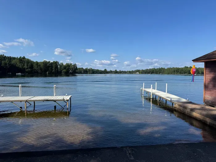 View from private boat docks (able to support 3-4 boats depending on size) and private swimming area along 500+ feet of sandy beach and lakeshore.  The boat docs form a protective shallow swim area great for young kids. 