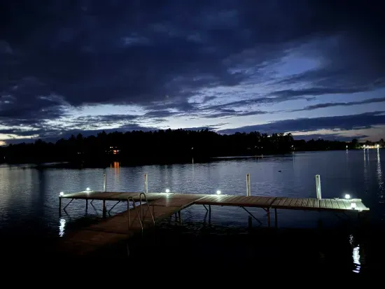 summer sunset view of the lake from 5RK lodge illuminated boat dock and swim area