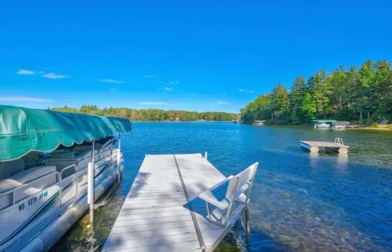Private boat and swimming dock along shallow sandy beach on crystal clear Little Round Lake with easy boat access to the entirety of Round Lake.