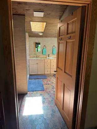 Master bedroom suite and private lake view balcony.  Master bedroom suite is setup with King Bed and connected to dual vanity master bathroom with sky-lights, cedar closet, and walk in tile rain shower.