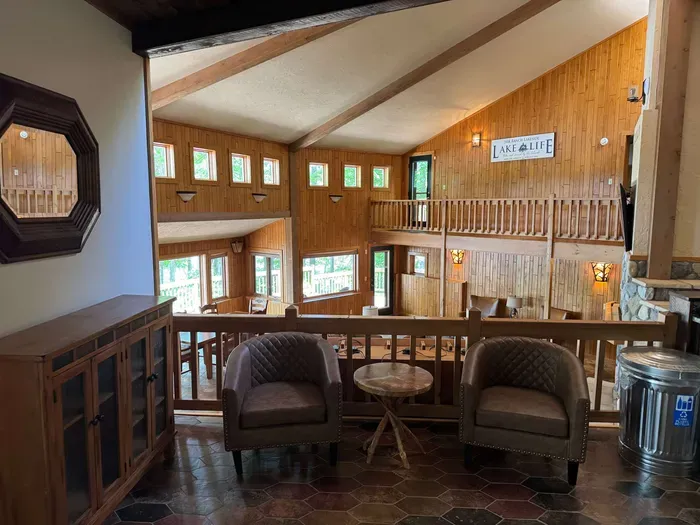 View from sitting area looking across the bi-level open floor plan with continuous views of the lake and floor plan that follows the contour of the lots' peninsula shoreline.  Gourmet eat-in kitchen, large great room, dining area, 65" smart TV, +more