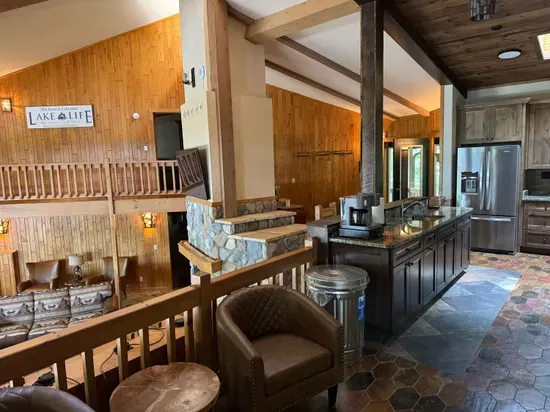 View from sitting area looking across the bi-level open floor plan with continuous views of the lake and floor plan that follows the contour of the lots' peninsula shoreline.  Gourmet eat-in kitchen, large great room, dining area, 65" smart TV, +more