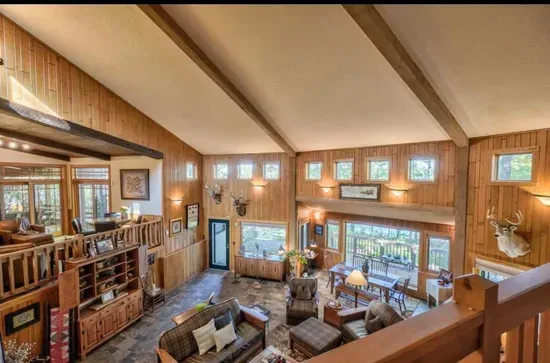 Second tier view down to the main level great room / hearth room living area within the Peninsula Lakehouse, with lake views from every place in the room!