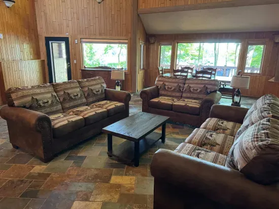 View of great room and formal dining area for 6 just off the living area surrounding the health and fireplace (not available for Guest use) and 65" smart TV mounted above the fireplace.
