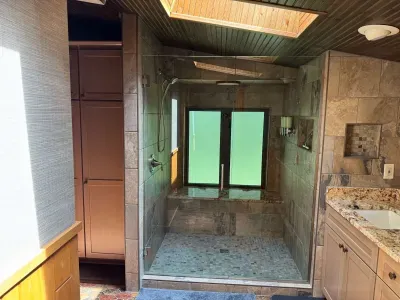 Master bedroom suite and private lake view balcony.  Master bedroom suite is setup with King Bed and connected to dual vanity master bathroom with sky-lights, cedar closet, and walk in tile rain shower.