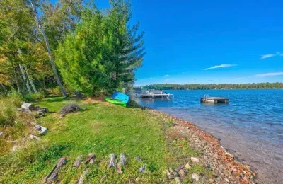 Private boat and swimming dock along shallow sandy beach on crystal clear Little Round Lake with easy boat access to the entirety of Round Lake.