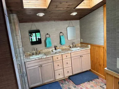 Master bedroom suite and private lake view balcony.  Master bedroom suite is setup with King Bed and connected to dual vanity master bathroom with sky-lights, cedar closet, and walk in tile rain shower.