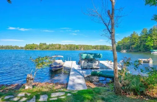 Private boat and swimming dock along shallow sandy beach on crystal clear Little Round Lake with easy boat access to the entirety of Round Lake.