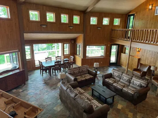 View of great room and formal dining area for 6 just off the living area surrounding the health and fireplace (not available for Guest use) and 65" smart TV mounted above the fireplace.