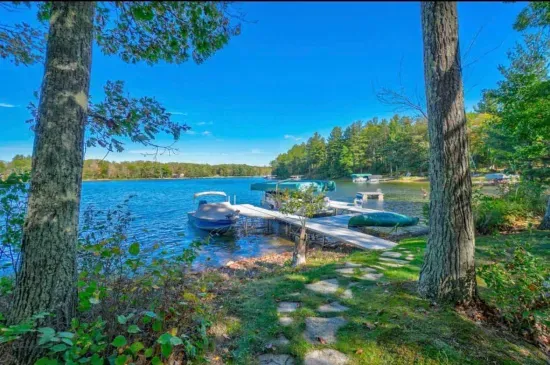 Private boat and swimming dock along shallow sandy beach on crystal clear Little Round Lake with easy boat access to the entirety of Round Lake.