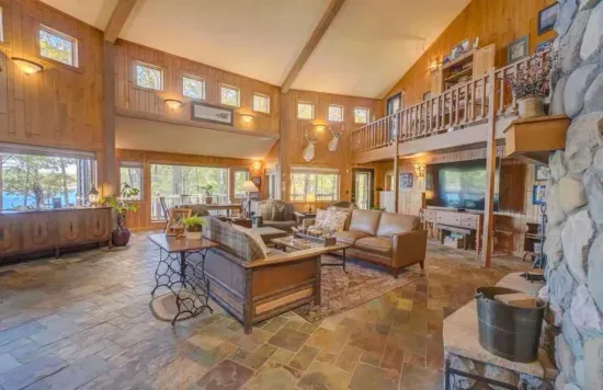 Main level great room / hearth room living area within the Peninsula Lakehouse, with lake views from every place in the room!