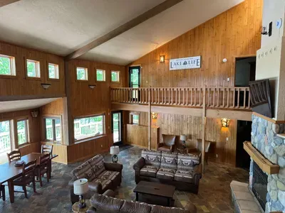 View from sitting area looking across the bi-level open floor plan with continuous views of the lake and floor plan that follows the contour of the lots' peninsula shoreline.  Gourmet eat-in kitchen, large great room, dining area, 65" smart TV, +more