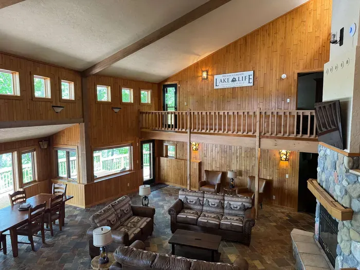 View from sitting area looking across the bi-level open floor plan with continuous views of the lake and floor plan that follows the contour of the lots' peninsula shoreline.  Gourmet eat-in kitchen, large great room, dining area, 65" smart TV, +more