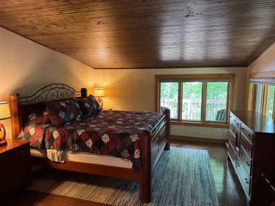 Master bedroom suite and private lake view balcony.  Master bedroom suite is setup with King Bed and connected to dual vanity master bathroom with sky-lights, cedar closet, and walk in tile rain shower.
