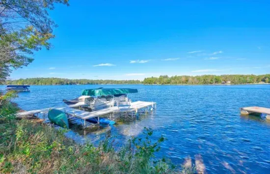 Private boat and swimming dock along shallow sandy beach on crystal clear Little Round Lake with easy boat access to the entirety of Round Lake.