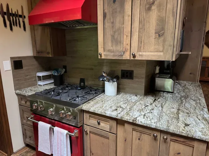 View of gourmet eat-in kitchen with gas stove top & oven within the Peninsula Lakehouse.  This is a bi-level open floor plan with continuous views of the lake and follows the contour of the lots' peninsula shoreline.