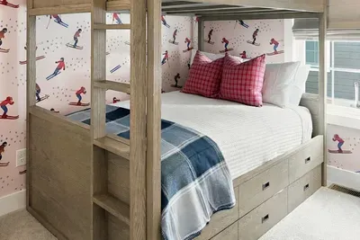 Bunk beds, ski wallpaper, and a toy boat — this room does not do boring.