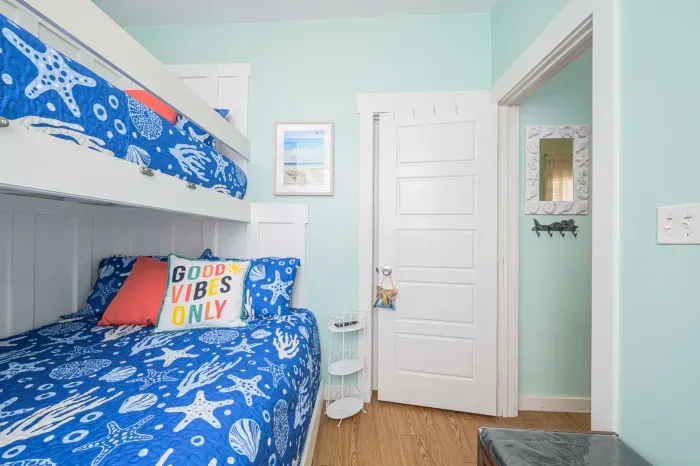 Fun Twin-over-Queen bunk bed in this vibrant bedroom featuring more coastal art