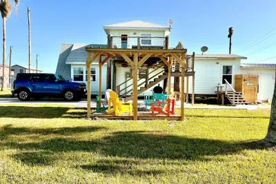 Patio with colorful chairs.  Perfect space to relax. Outdoor shower in the background next to casita with stairs