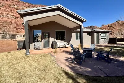 Fenced in backyard with grill and fire pit