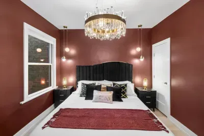 Featuring a black wave curved velvet king bed, crystal-and-gold chandelier, elegant pendant lights, 55'' Roku TV, Cloth hanging rack, full dressing mirror,