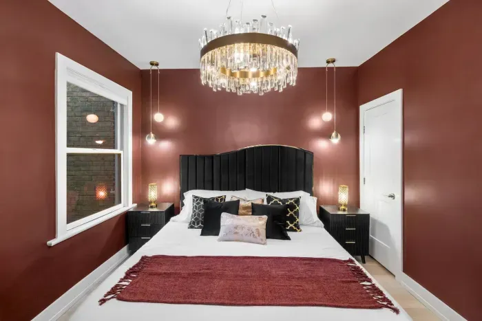 Featuring a black wave curved velvet king bed, crystal-and-gold chandelier, elegant pendant lights, 55'' Roku TV, Cloth hanging rack, full dressing mirror, 