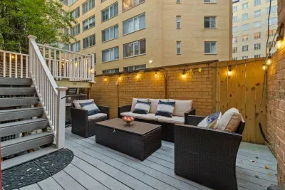 The private backyard patio is strung with romantic lights and furnished with comfortable seating and coffee tables, perfect for enjoying morning coffee or an evening glass of wine under the stars.