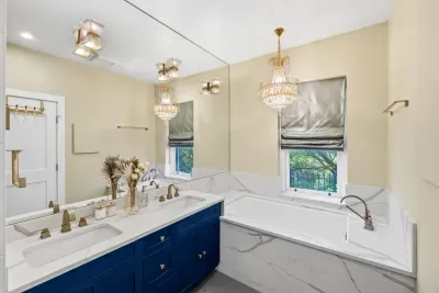Featuring double royal blue vanities, vanity lights and a sparkling crystal chandelier, spa-style soaking tub with massage jets