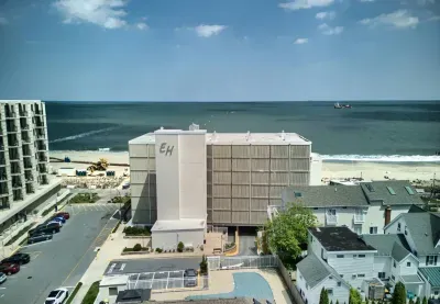 Back of the Building, including the driveway leading to the underground parking and the outdoor pool.