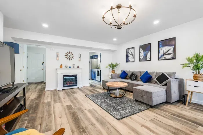 Living room with 6 seat sofa (can be re-arranged as a queen bed), 60'' smart TV (complimentary Sling TV), electronic fireplace