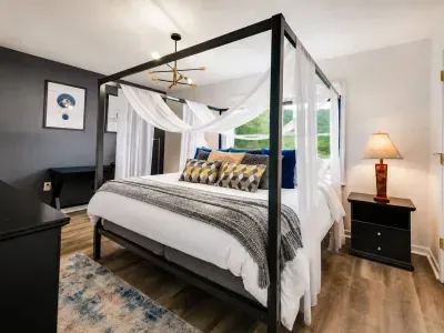 Master bedroom with King Canopy Bed, Mountain View, Work Desk, Smart TV and Ensuite Bathroom.